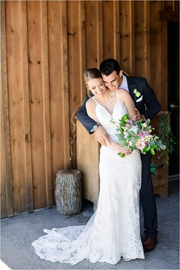 Bride and Groom hugging on the porch of their wedding venue at Irishman Acres Barn
