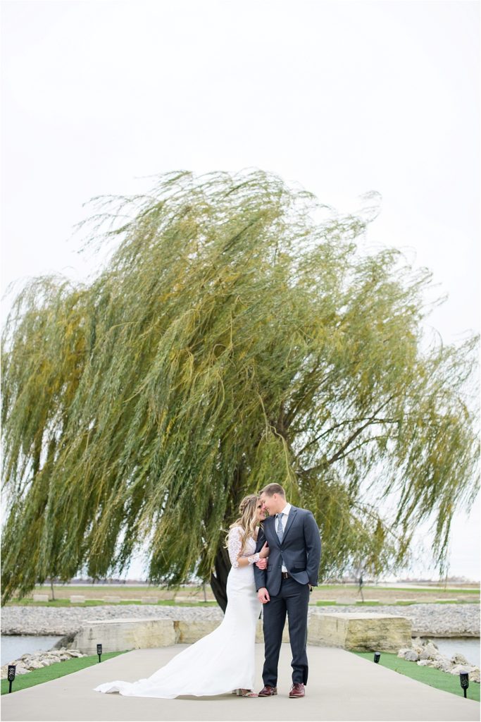 Bride and Groom in front of a willow tree at Epic Event Center in Marion, Iowa